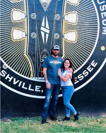 David Eason and Jenelle Evans posing infront of big picture written Musicians Hall Of Fame & Museum.